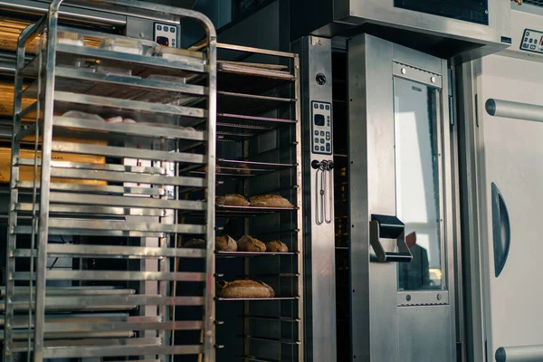 新鮮で香りの良いパンは プロのオーブン近くの小麦粉製品のクラフト生産の棚にあります — ストック写真