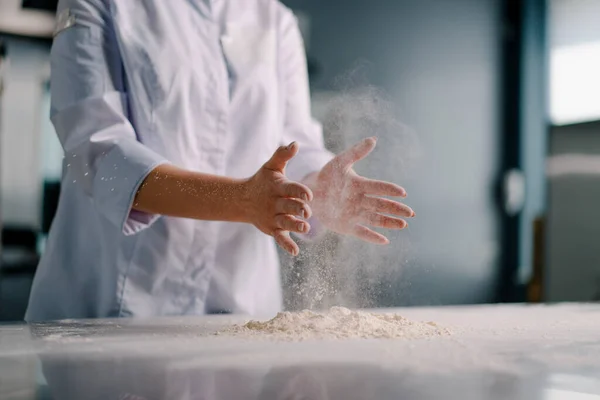 一位经验丰富的厨师在一家面包店做面包之前 先把面粉涂在手上 然后再在专业厨房里准备糕点 — 图库照片