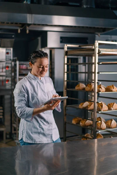 Een Vrouw Bakker Een Uniform Buurt Van Planken Met Vers — Stockfoto