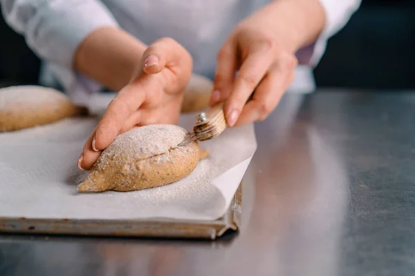 Kobieta Piekarz Tnie Wzory Surowych Bułkach Chlebowych Profesjonalnym Nożem Piekarskim — Zdjęcie stockowe
