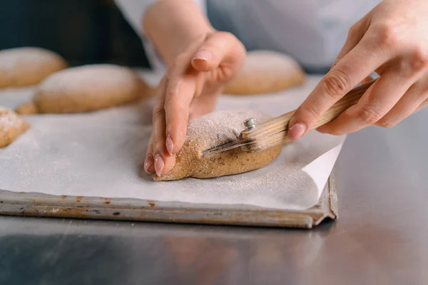 Kobieta Piekarz Tnie Wzory Surowych Bułkach Chlebowych Profesjonalnym Nożem Piekarskim — Zdjęcie stockowe