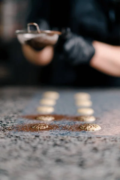 糖果店通过筛子把巧克力撒在模子里制作手工制作的糖果专业厨房 — 图库照片