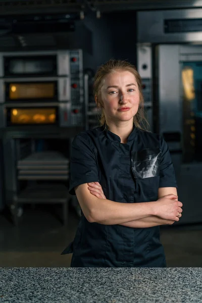 Profesyonel mutfakta çalışmaya başlamadan önce iş yerinde üniformalı profesyonel bir şekerci duruyor.