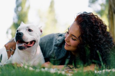 Pitbull 'un güzel beyaz köpeği, Stamfordshire Teriyeri' ni otların üzerinde sahibinin yanında yürüyüşe çıkarmış.