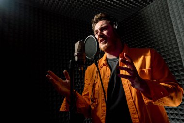 Genç pop rap sanatçısı mikrofonla yeni şarkılar kaydediyor.