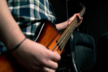 Kayıt stüdyosunda elektro gitarlı bir rock sanatçısı kendi şarkısını çalıyor şarkı enstrümanlarını yaratıyor.