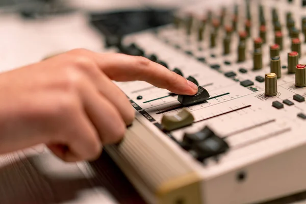 专业的录音室音响工程师用手指调整音量水平混合控制台均衡器制作音乐特写 — 图库照片