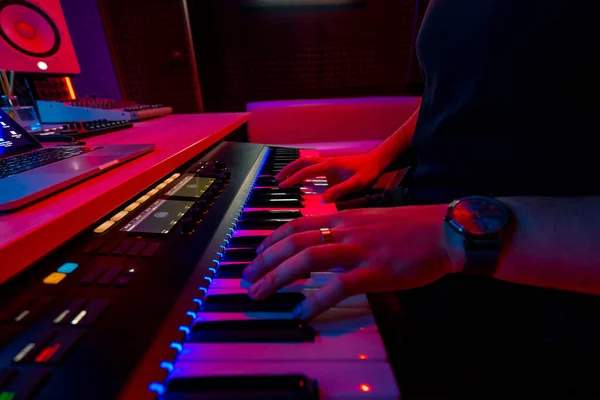 专业录音室音响工程师音乐制作人音乐家按合成器键红色霓虹灯 — 图库照片