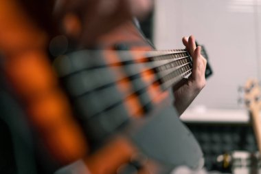Kayıt stüdyosunda elektro gitarlı bir rock sanatçısı kendi şarkısını çalıyor şarkı enstrümanlarını yaratıyor.