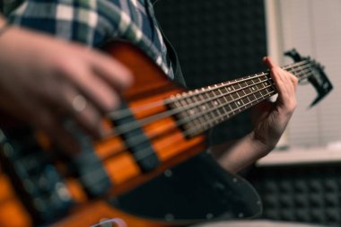 Kayıt stüdyosunda elektro gitarlı bir rock sanatçısı kendi şarkısını çalıyor şarkı enstrümanlarını yaratıyor.
