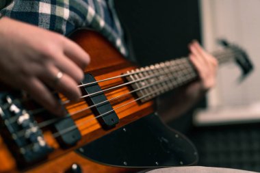 Kayıt stüdyosunda elektro gitarlı bir rock sanatçısı kendi şarkısını çalıyor şarkı enstrümanlarını yaratıyor.