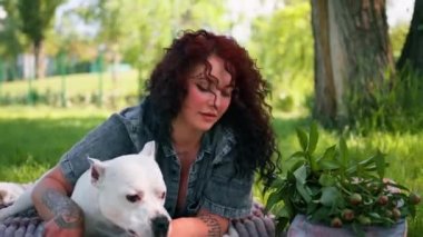 Güzel beyaz köpek pitbull staffordshire terrier parkta yürüyüş yaparken sahibinin onu yalarken dinlenmesi.