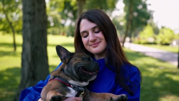 Joven Dueña Sostiene Pequeño Bulldog Francés Sus Brazos Que Sonríe — Vídeo de stock