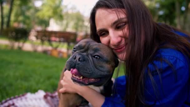 Joven Dueña Sostiene Pequeño Bulldog Francés Sus Brazos Que Sonríe — Vídeos de Stock