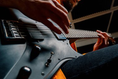 Kayıt stüdyosunda elektro gitarlı bir rock sanatçısı kendi şarkısını çalıyor şarkı enstrümanlarını yaratıyor.