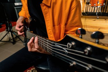 Kayıt stüdyosunda elektro gitarlı bir rock sanatçısı kendi şarkısını çalıyor şarkı enstrümanlarını yaratıyor.