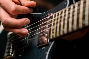 Kayıt stüdyosunda elektro gitarlı bir rock sanatçısı kendi şarkısını çalıyor şarkı enstrümanlarını yaratıyor.