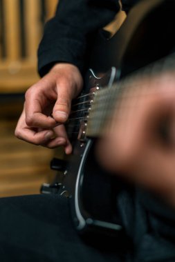 Kayıt stüdyosunda elektro gitarlı bir rock sanatçısı kendi şarkısını çalıyor şarkı enstrümanlarını yaratıyor.