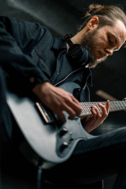 Kayıt stüdyosunda elektro gitarlı bir rock sanatçısı kendi şarkısını çalıyor şarkı enstrümanlarını yaratıyor.