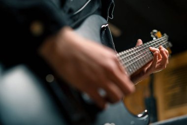 Kayıt stüdyosunda elektro gitarlı bir rock sanatçısı kendi şarkısını çalıyor şarkı enstrümanlarını yaratıyor.