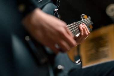 Kayıt stüdyosunda elektro gitarlı bir rock sanatçısı kendi şarkısını çalıyor şarkı enstrümanlarını yaratıyor.