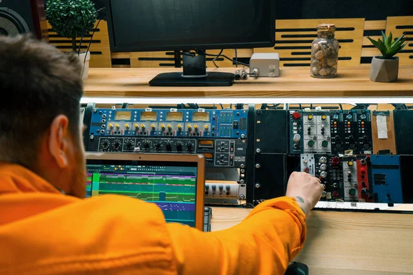 若いサウンドエンジニアは ミュージックスタジオでモニターとイコライザーミキシングと曲の録音オーディオトラック画面をマスタリング — ストック写真