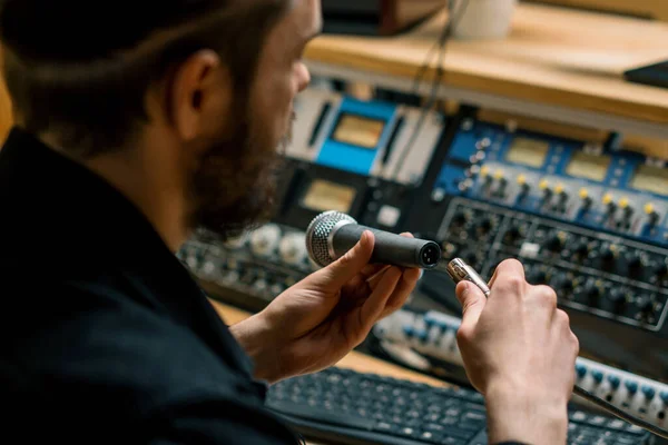 サウンドエンジニアはプロのレコーディングスタジオのクローズアップハンドで音楽機器にマイクを接続します — ストック写真
