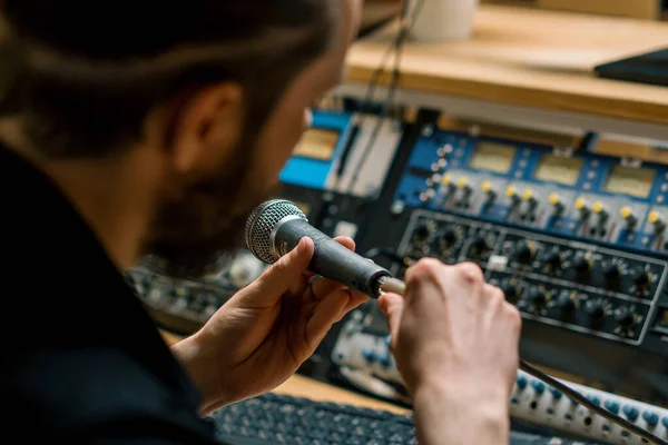 サウンドエンジニアはプロのレコーディングスタジオのクローズアップハンドで音楽機器にマイクを接続します — ストック写真