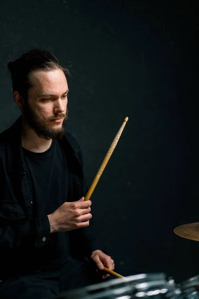 drummer plays a drum kit in a recording studio at a professional musician rehearsal recording a song beats the sticks on the instrument closeup