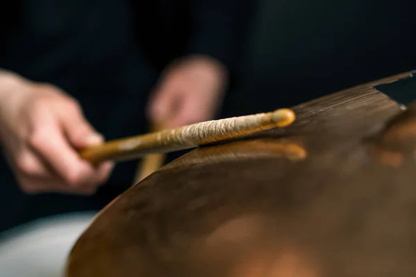 鼓手在一个专业音乐家排练的录音室里演奏一个鼓包 该录音室记录了一首歌 并在乐器特写上敲击木棍 — 图库照片
