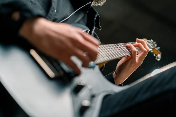 rock performer with electric guitar in recording studio recording playing own track creating song musical instrument strings closeup
