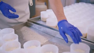 Bir el işi peynir fabrikasında çalışan bir işçi peyniri kuru temizlemeye verir.
