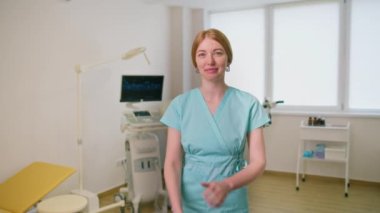 Jinekolog gülümseyen bir jinekolog, ultrason ve jinekolog muayenehanesinde hastaları bekliyor.