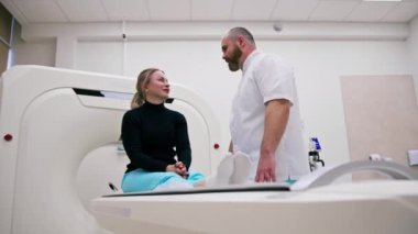 Röntgen taraması yapılmadan önce bir doktor klinikte bir hastaya danışıyor.