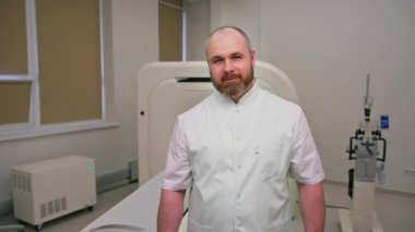 Gülümseyen sakallı doktor bilgisayarlı tomografi ofisinde işe başlamadan önce hastaları bekleyen tomografi uzmanı.