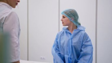 Tıbbi klinikteki profesyonel bir radyolog, manyetik rezonans görüntüleme işleminden önce hastaya tavsiyede bulunur.