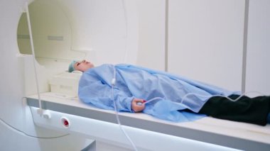 Doktor, klinikteki bir hasta için insan vücudunun manyetik rezonans görüntülerini tarıyor.