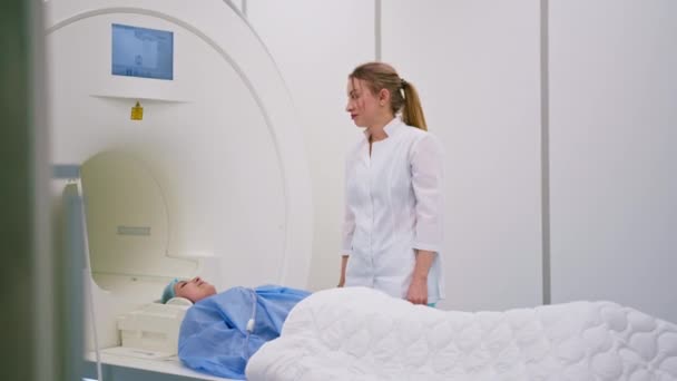医疗诊所的专业放射学家会监察正在接受磁共振显像程序的病人 — 图库视频影像