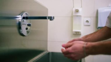 Klinikte dezenfeksiyon işlemi cerrah ameliyattan önce ellerini lavaboda yıkar.