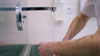 Klinikte dezenfeksiyon işlemi cerrah ameliyattan önce ellerini lavaboda yıkar.