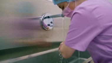 Klinikte dezenfeksiyon işlemi cerrah ameliyattan önce ellerini lavaboda yıkar.