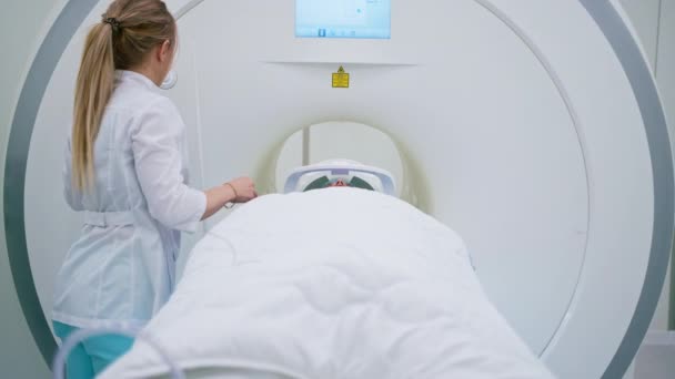 診療所の放射線専門医が磁気共鳴画像法を受けている患者を監視します — ストック動画
