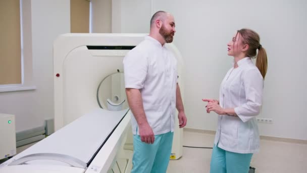 磁気共鳴イメージングコンセプトの職業と医学の近くで行われた実施された研究を議論する制服の笑顔と満足の医師 — ストック動画