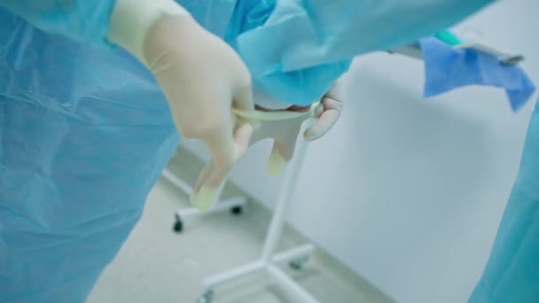Pielęgniarka Pomaga Chirurgowi Zakładać Sterylne Rękawice Przed Zabiegiem Chirurgicznym — Wideo stockowe