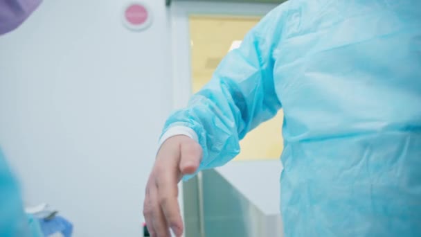 Sjuksköterska Hjälper Kirurgen Att Sig Sterila Handskar Före Operation Enhetlig — Stockvideo
