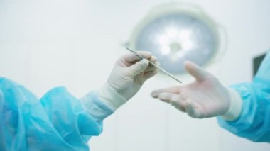 Steril eldivenli hemşire ya da cerrah yakın plan ameliyat sırasında kafa derisi cerrahisini ellerinde tutuyorlar.