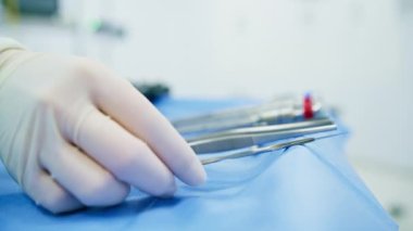 Steril eldivenli bir hemşire hastanede ameliyat sırasında cerraha cerrahi aletler veriyor.