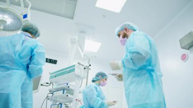 Doktor-cerrah, hemşire ameliyat sırasında şaşkın duruyor ve hastayı nasıl kurtaracağını bilmiyor.