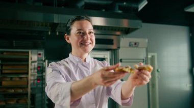 Güzel kadın fırıncı gözyaşları taze pişmiş sıcak aromalı çörekler hamur fırını üretimini kontrol eder.