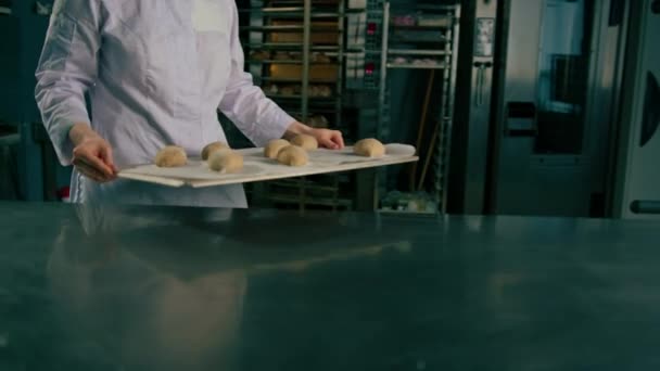 Konzentrierte Schöne Bäckerin Legt Ein Backblech Mit Rohem Teig Auf — Stockvideo